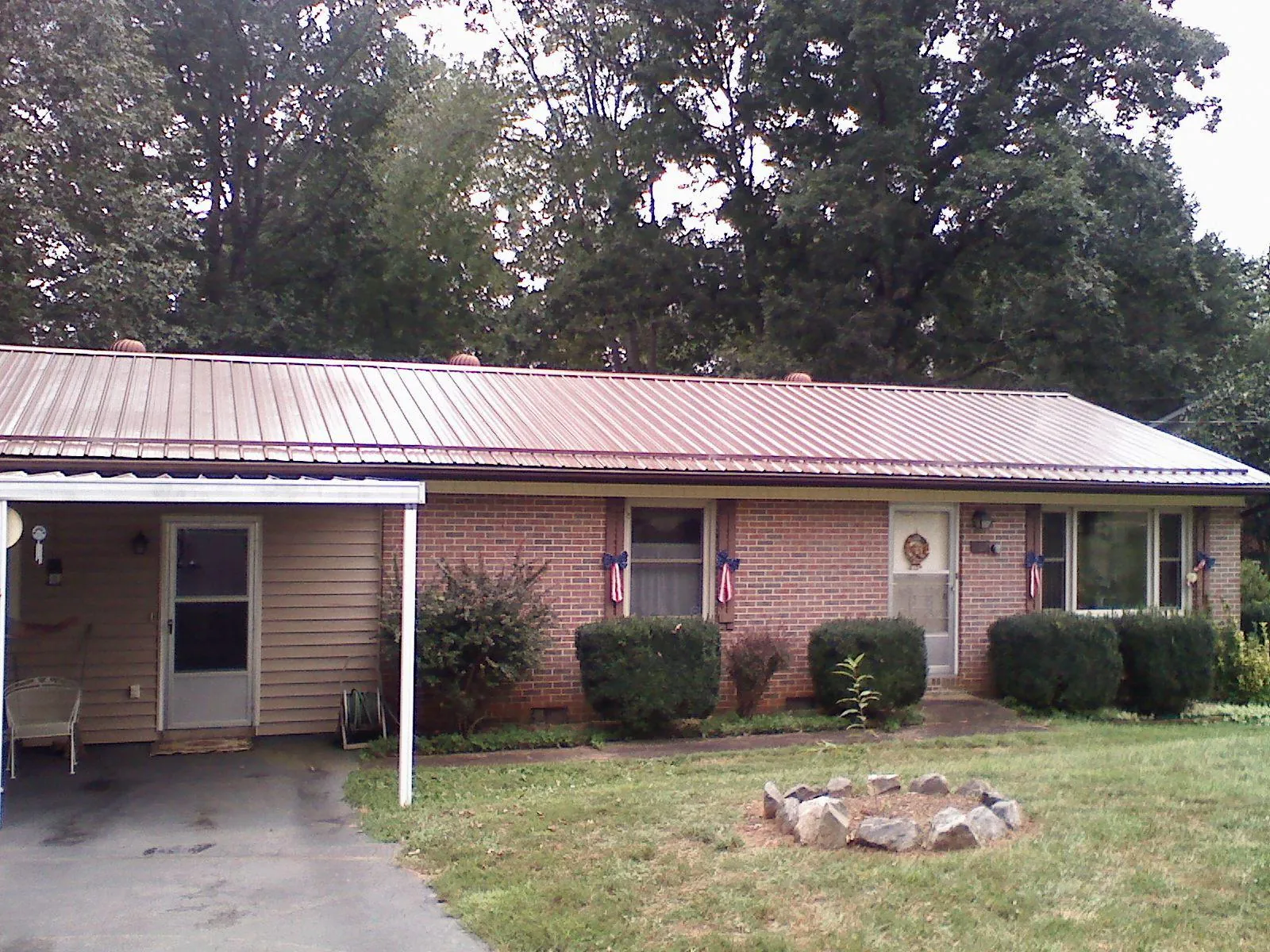 Bronze metal roof and carport on a brick ranch home — Roof Repair work by our crew in Tougaloo