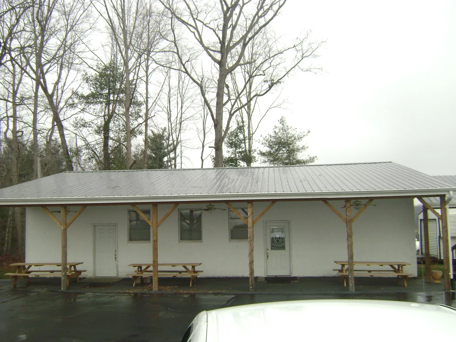 Gray metal roof over a block building with a timber post porch in Tougaloo