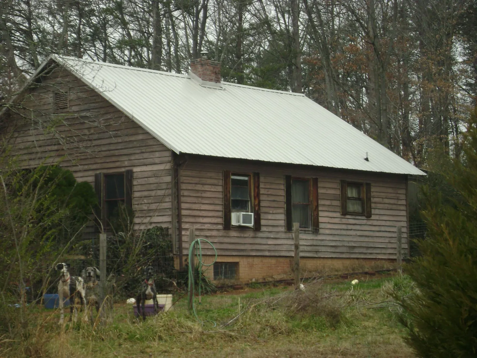White metal roof on an old wood sided farmhouse, from a Metal Roof Installation job in Tougaloo